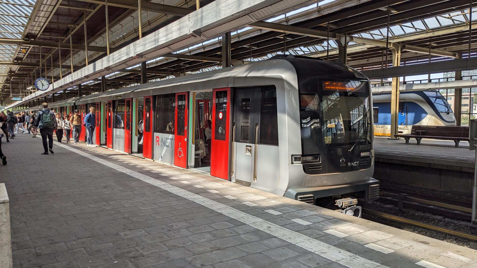 Metro train at platform with passengers entering and leaving.