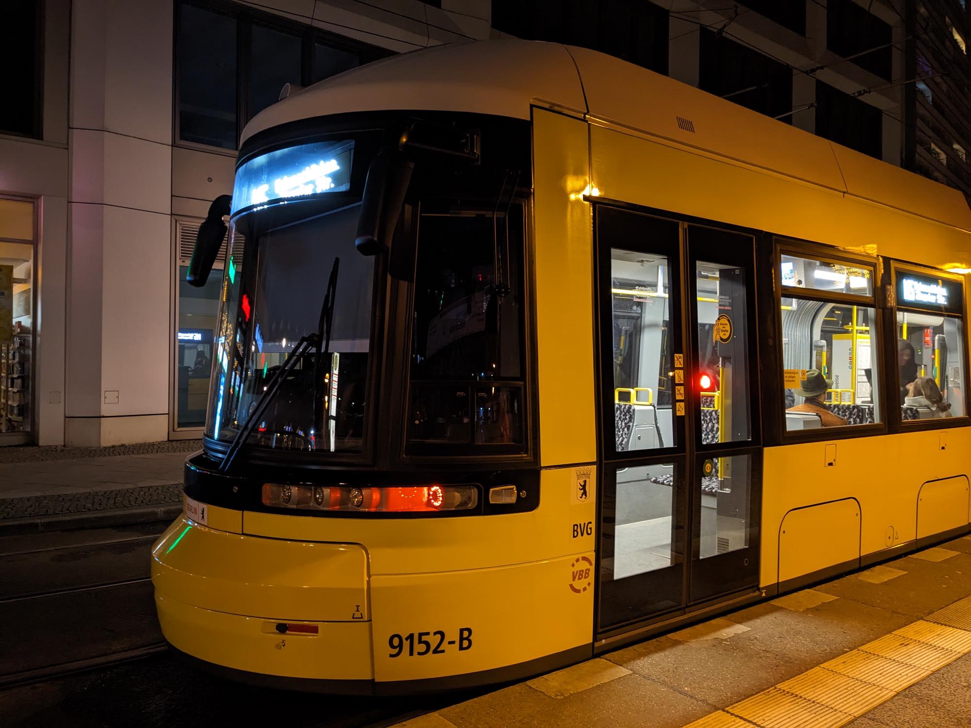 Yellow Flexity Berlin tram at the platform in the dark.