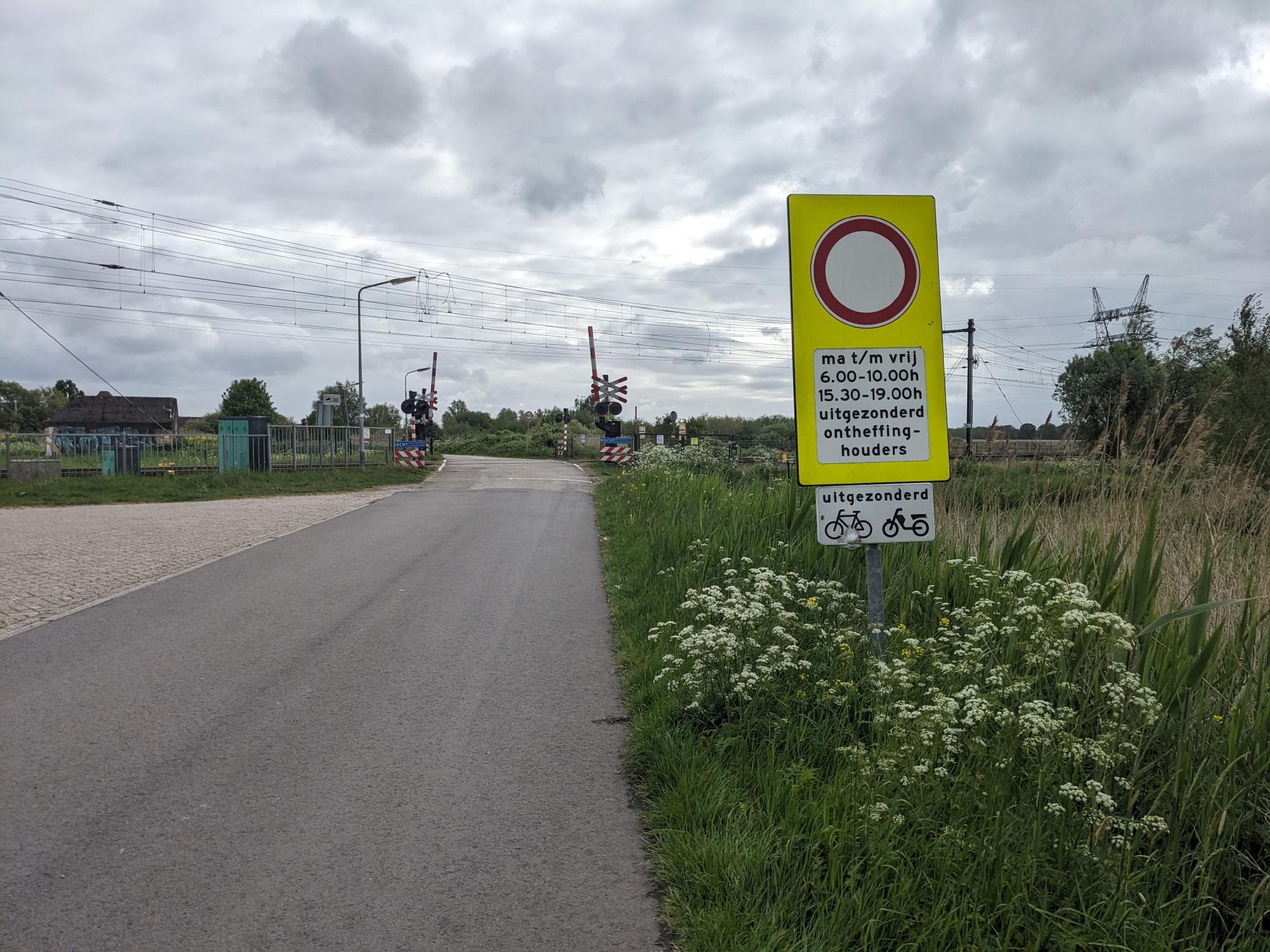 Railway crossing and road sign restricting traffic to only residents during the middile of the work week except bicycles and snorfietsen